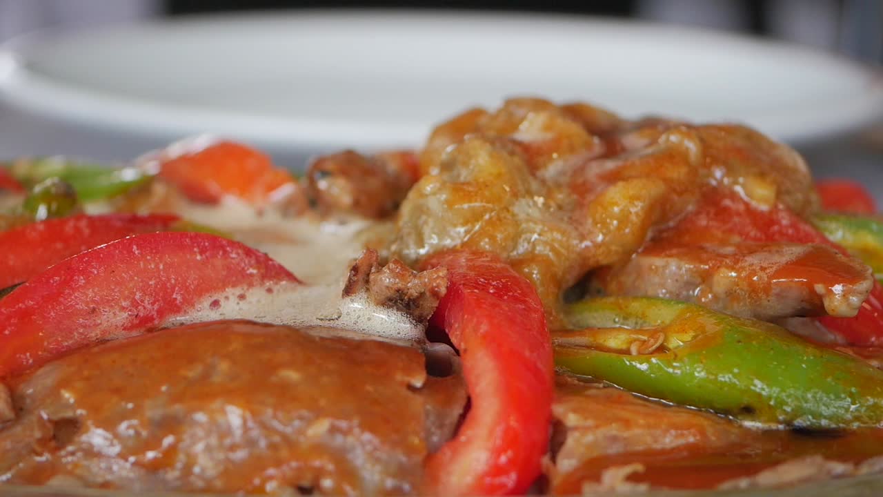 primer plano de un plato turco con carne, tomates y pimientos verdes