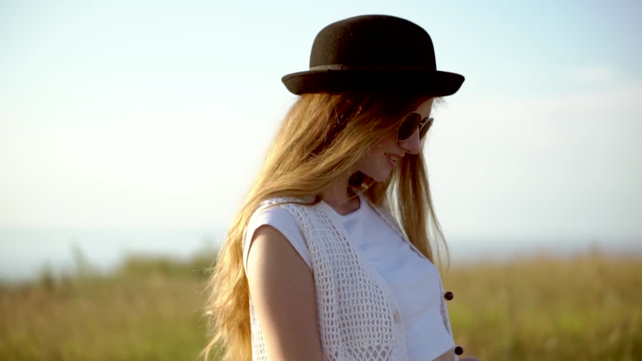 mujer en el campo con sombrero y gafas de sol