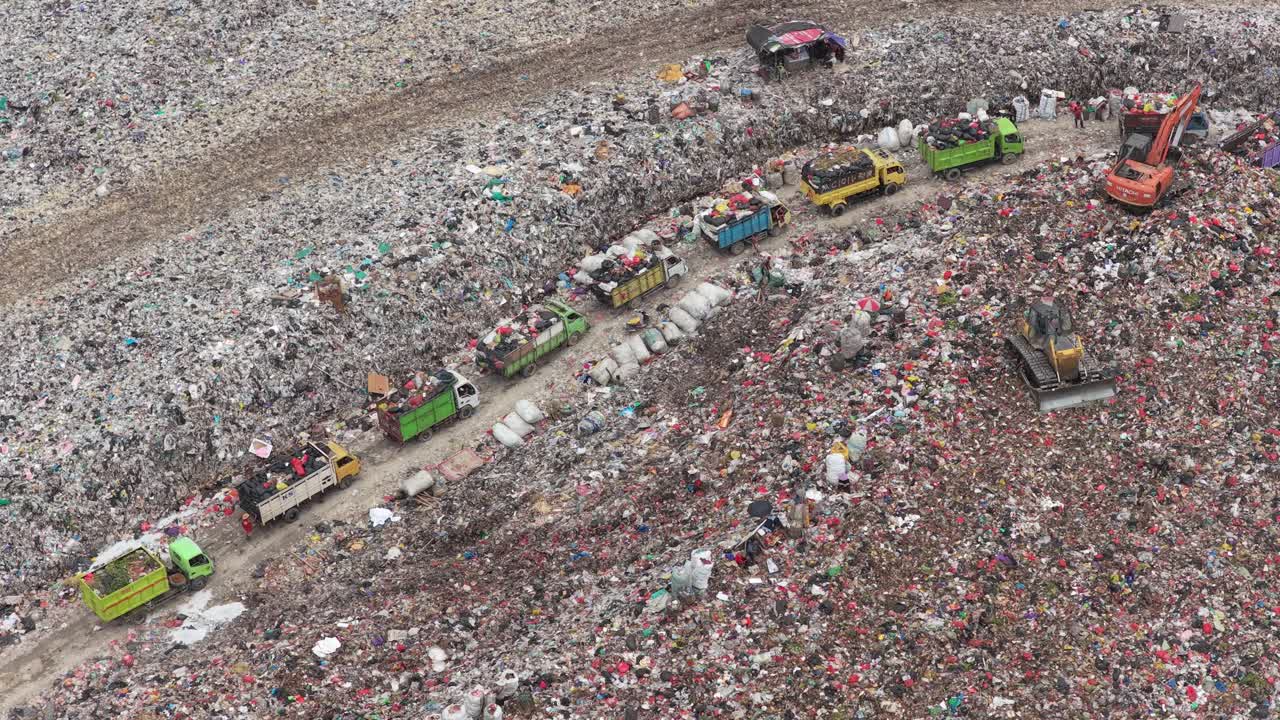 Vista aerea di una grande discarica con camion e operai