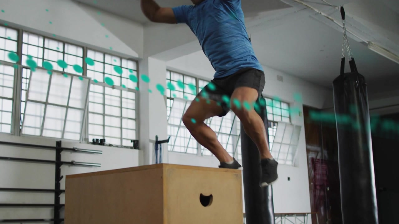 Male athlete loading hips, swinging arms, jumping onto plyo box for fitness, teal graphic crossing