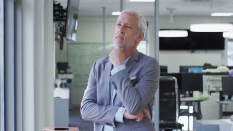 Thoughtful-man-rubbing-his-chin-in-office