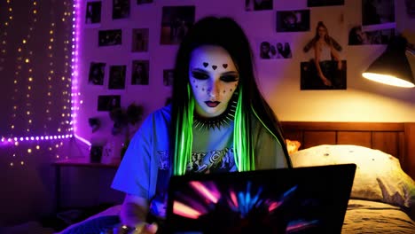 woman with glowing hair looking at a laptop in her bedroom