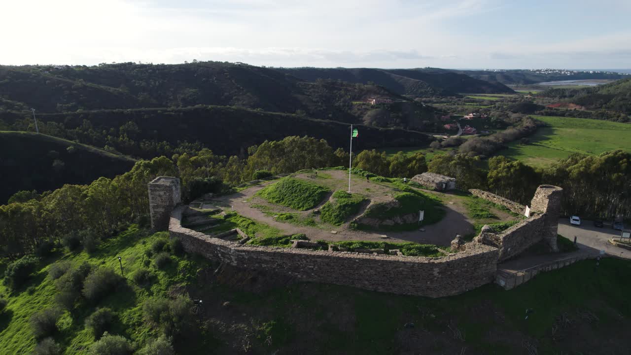 Omløbsoptagelse over Aljezur slot, portugisisk flag vajende i vinden, Portugal