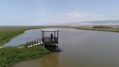 A tranquil wetland with a wooden observation deck overlooking calm waters. Perfect for eco-tourism, nature blogs, and conservation themes. Mejia, Arequipa, Peru.
