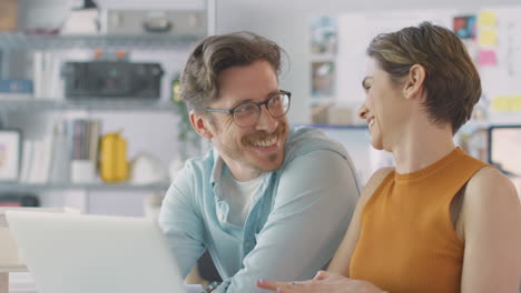 Male-And-Female-Architects-In-Office-Working-At-Desk-On-Laptop-Having-Meeting-Together