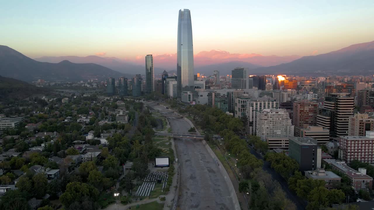 Parallasse aerea di cinema all'aperto gratuito, fiume Mapocho, grattacielo di Sanhattan e colline sullo sfondo all'ora blu a Providencia, Santiago, Cile