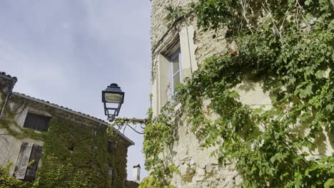 alte straßenlampe an einer alten hauswand eines französischen steinhauses bei gutem wetter