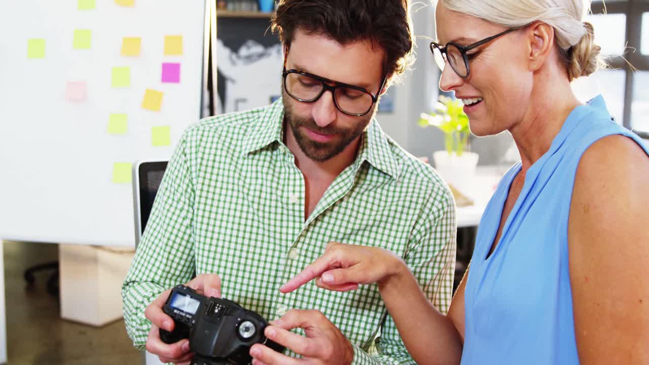 diseñadores gráficos mirando imágenes en cámaras digitales