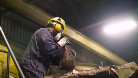 plant worker moves large blocks of metal at heights