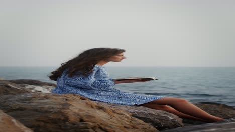 mujer leyendo junto al mar