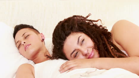 smiling lesbian couple together in the bed