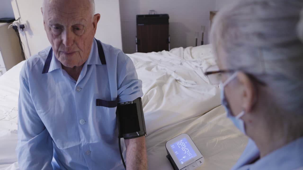 Elderly man getting blood pressure checked by nurse
