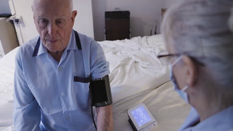 elderly man getting blood pressure checked by nurse