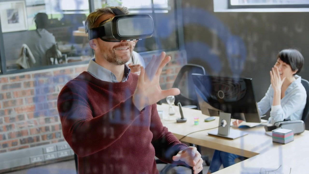 Animazione di icone digitali ed elaborazione dati su un uomo caucasico che indossa un visore VR in ufficio