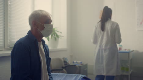 Anciano-Esperando-Un-Examen-Médico-En-La-Clínica-De-Cerca.-Médico-Preparando-La-Prueba.