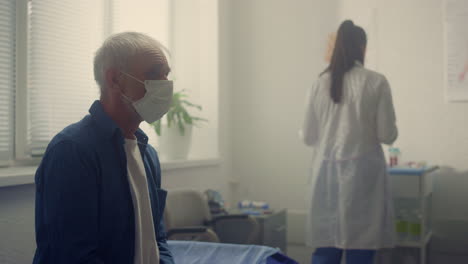 old man waiting medical examination in clinic close up. doctor preparing test.