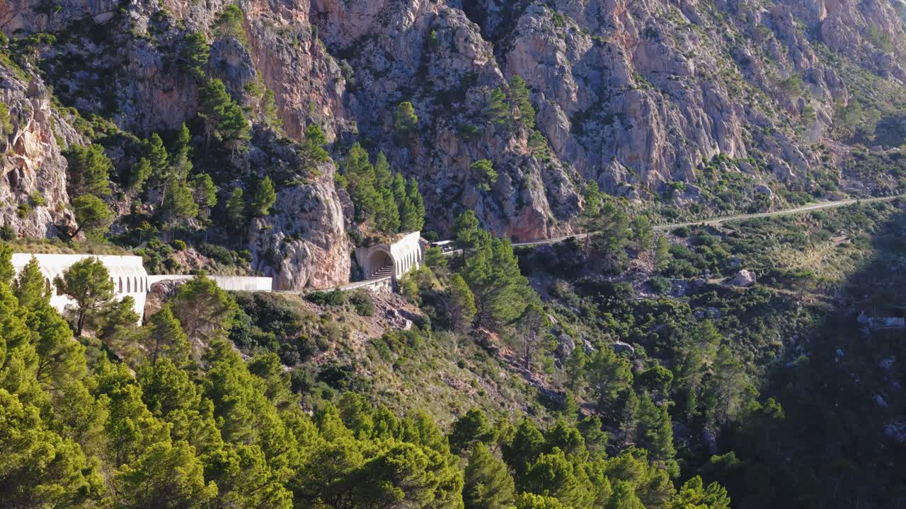 Straße am Hang führt durch Tunnel auf Mallorca, Spanien
