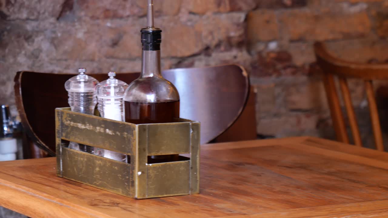 sal y pimienta y una botella de aceite en una mesa de madera en un restaurante