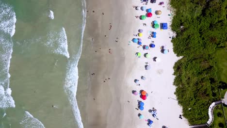 Toma-Aérea-De-Arriba-Hacia-Abajo-Del-Mar-A-La-Izquierda-Y-La-Playa-De-Bombinhas-A-La-Derecha-Del-Marco