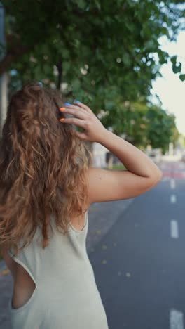 woman with curly hair walking in the city