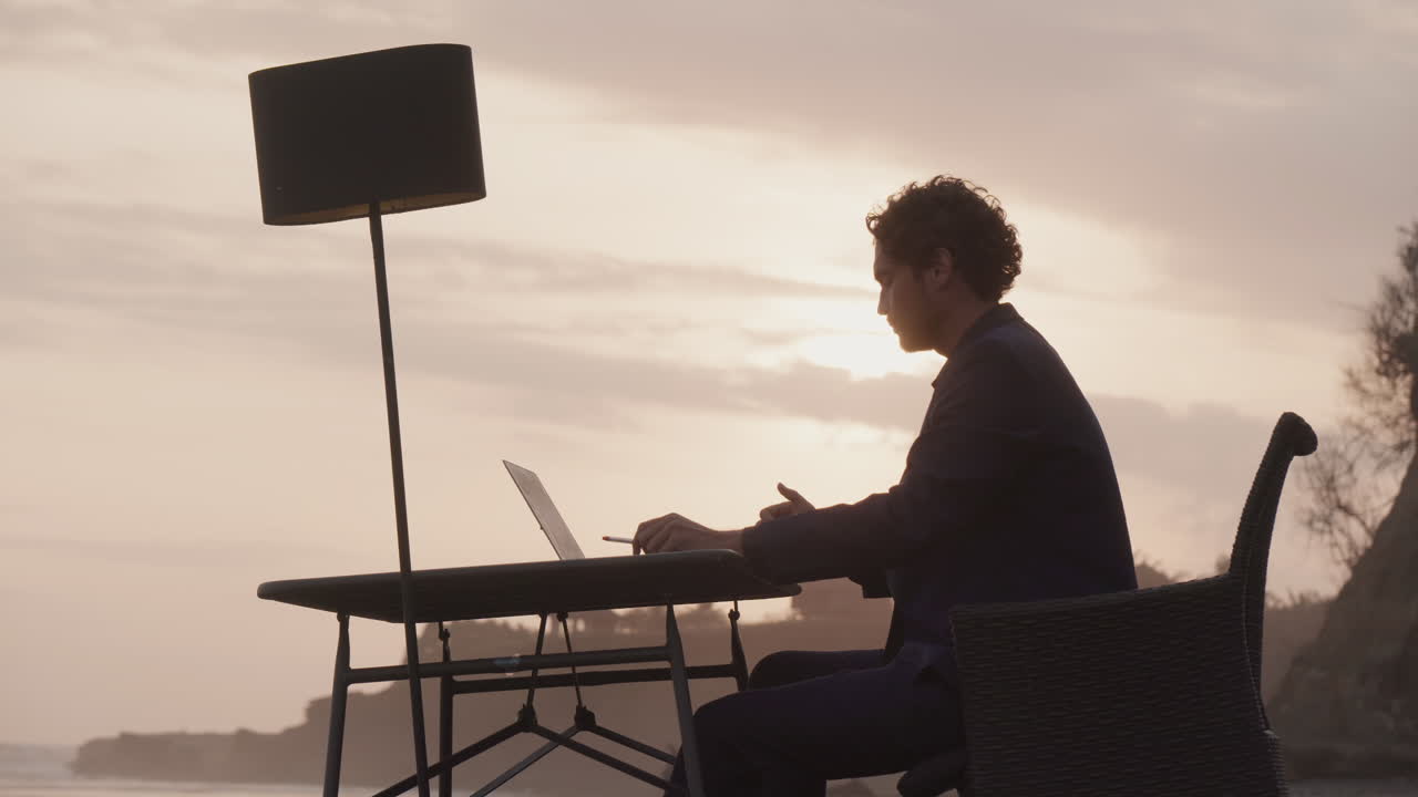 Uomo d'affari al lavoro all'aperto al tramonto