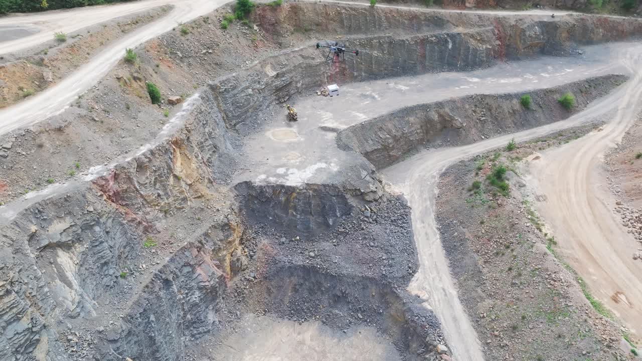 High angle view of delivery drone with cargo attached hover over quarry, Czechia