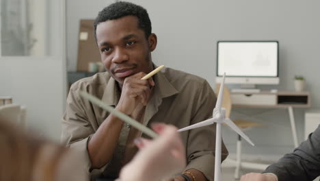 portrait of an man discussing about renewable energy project with his colleagues in the office