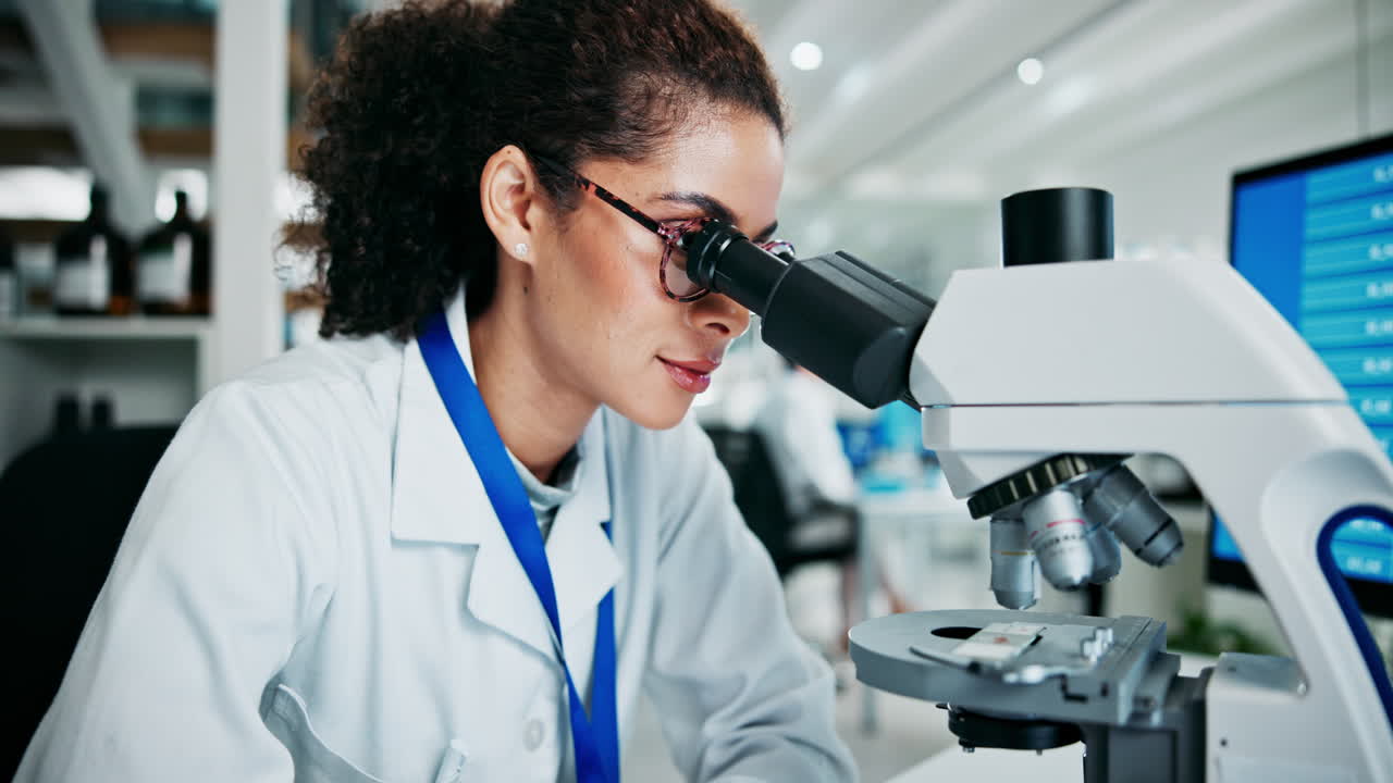 científico usando el microscopio y la tableta en el laboratorio