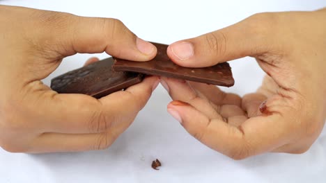 rompiendo chocolate negro con la mano en cámara lenta ,