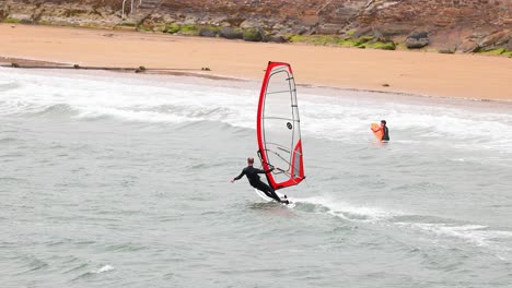 windsurfer gliding along the beach in scotland