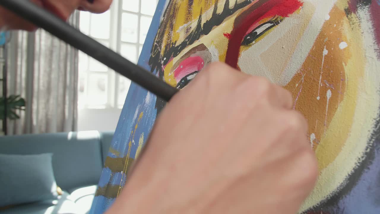 un hombre artista asiático con un pincel de colores mixtos y pintando la cara de una chica en el lienzo