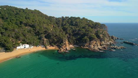 Cautivadoras-Vistas-Aéreas-Muestran-El-Esplendor-De-Lloret-De-Mar-Y-El-Encanto-Prístino-De-Cala-Canyelles,-Ubicada-A-Lo-Largo-De-La-Impresionante-Costa-Brava