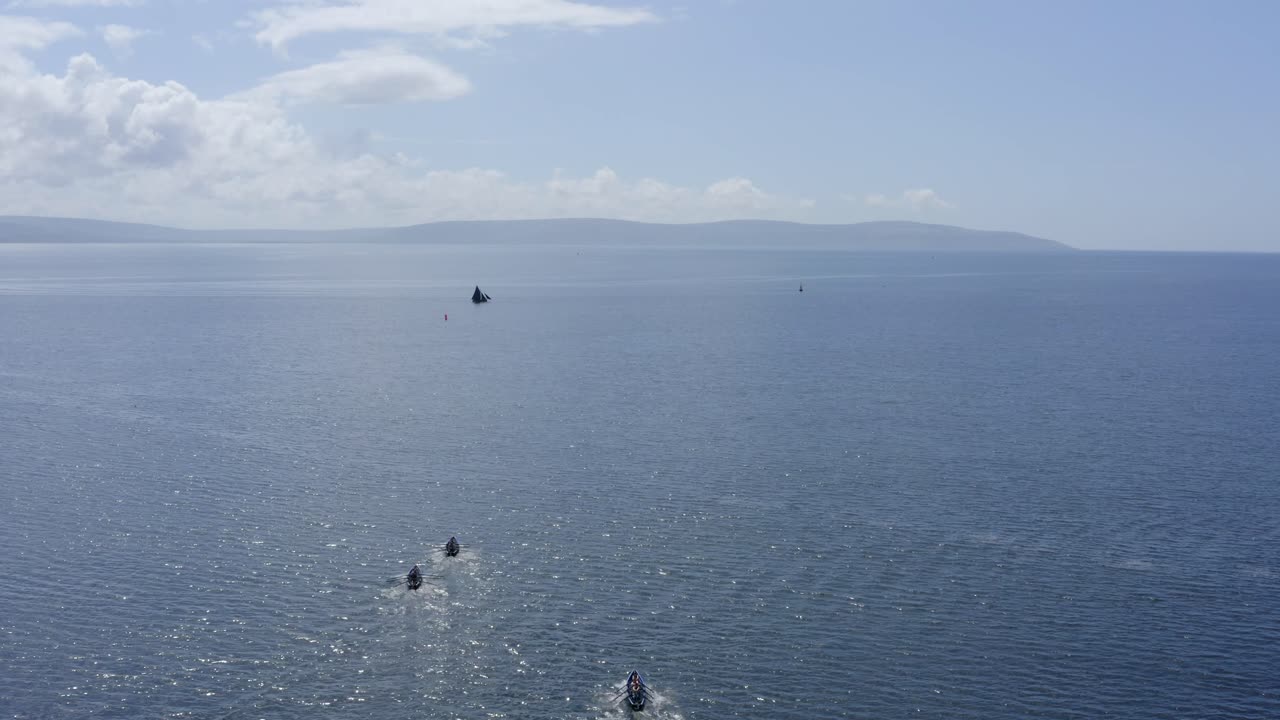 el avión no tripulado desciende sobre los barcos de currach que corren hacia el país de clare, galway, irlanda.