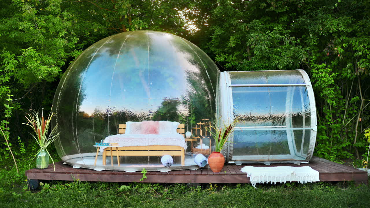 View of a transparent bubble tent at glamping with furniture inside. Nature around