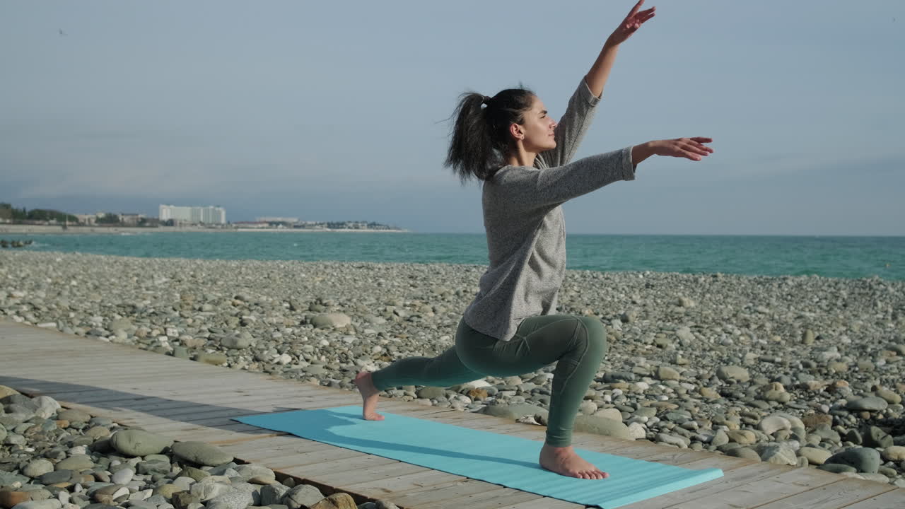 Donna che pratica yoga su una spiaggia