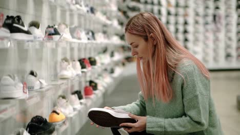 Comprando-En-La-Tienda-De-Zapatos,-La-Mujer-Está-Eligiendo-Zapatillas