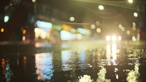 Autobús-Londinense-Pasando-Detrás-De-La-Lluvia-Cayendo-En-Un-Charco-Noche-En-Cámara-Super-Lenta