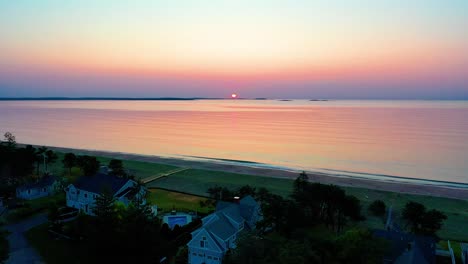 Hermosa-Puesta-De-Sol-En-La-Playa-En-Saco-Maine-Con-Colores-Reflejándose-En-Las-Olas-Del-Océano-Y-Casas-De-Vacaciones-A-Lo-Largo-De-La-Costa-Atlántica-De-Nueva-Inglaterra