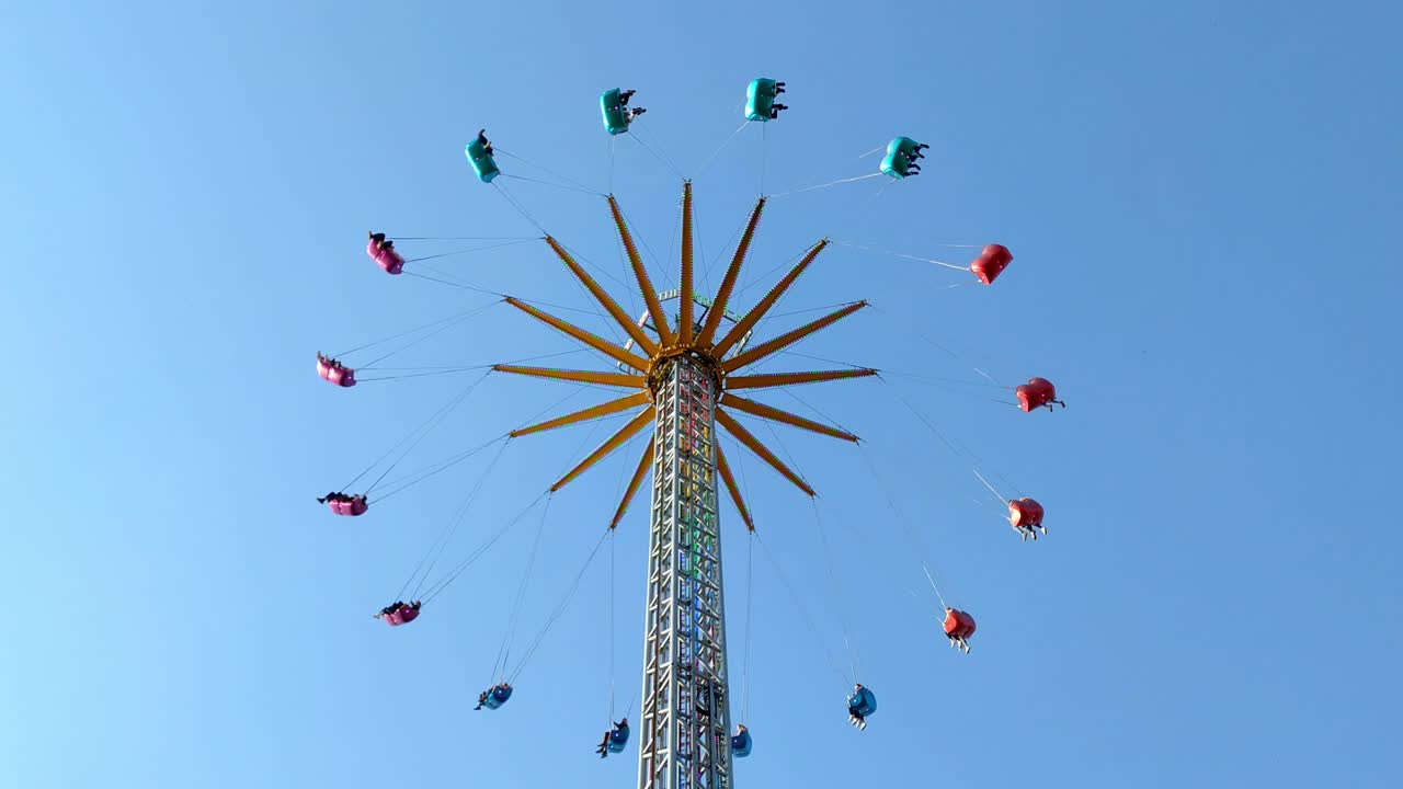 수직 다채로운 체인 페어 스윙 회전 사람들, 대칭 최소한의 배경 푸른 하늘, 정적