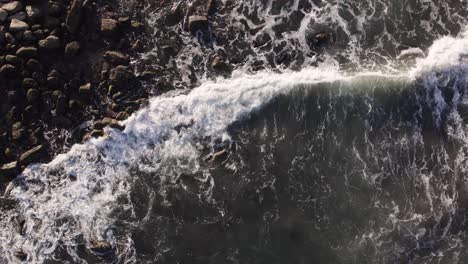 waves breaking at the golden hour drone top view in slowmotion