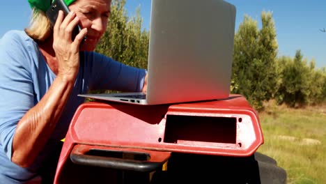 Woman-using-laptop-while-talking-on-mobile-phone-4k