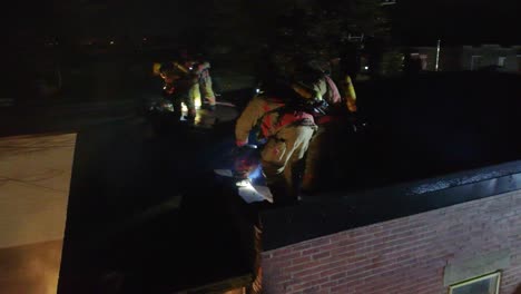 firefighters on roof at night during emergency response