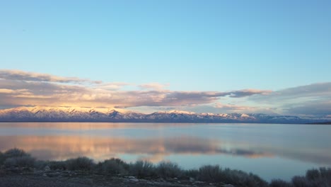 Utah-mountains-mirrored-on-the-lake-as-sun-goes-down-and-foreground-wizzes-by