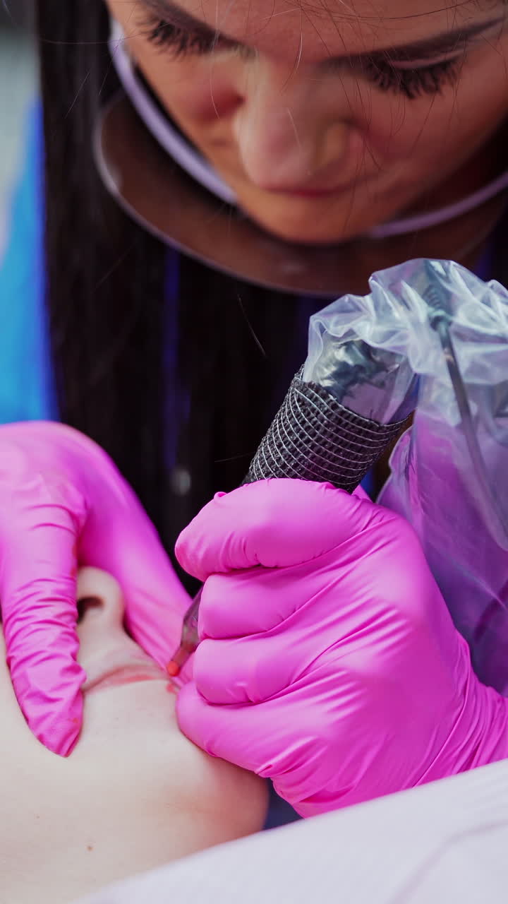 Woman making permanent makeup in salon. Young beautiful woman having permanent make up tattoo on lips
