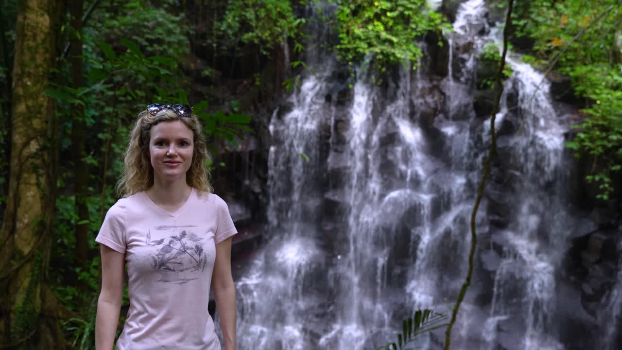 Blonde Tourist Woman Visiting Kanto Lampo Waterfall Cascades In Bali, Indonesia