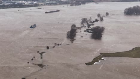 aerial view of rainfall and high water level along the waal river in varik, gelderland, netherlands