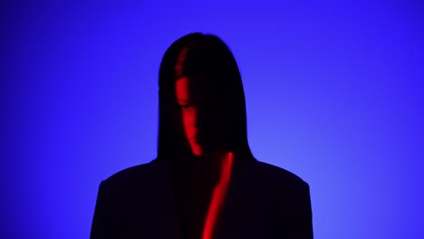 mysterious person in dramatic blue and red lighting effect a person is captured in dramatic lighting featuring vivid blue and red shadows creating a mysterious and intriguing visual effect