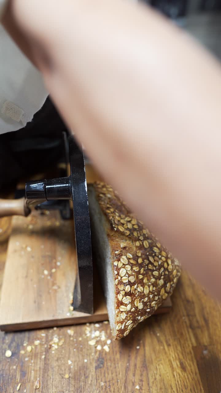 un panadero cortando un trozo de pan