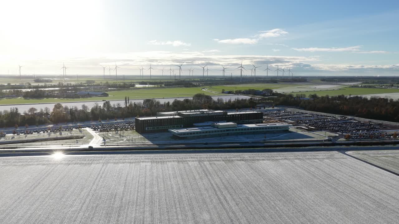 Aerial drone video footage of the modern Ommelander Hospital in Scheemda, Groningen, in a winter landscape. The facility is a sustainable, energy-efficient, and welcoming healthcare building