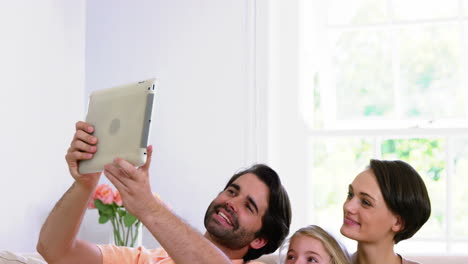 familia linda sonriendo y tomando una foto con una tableta